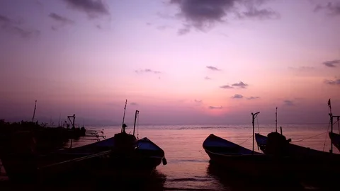 Sunset on beach time lapse. Fishing boats moored to sea shore. Pink sky, clouds Stock Footage 129647909