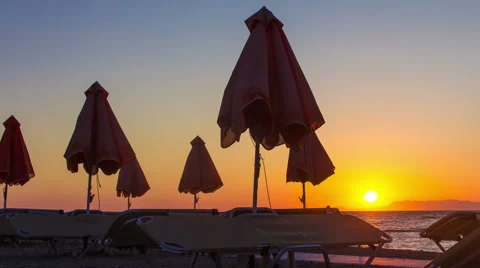 Sunset on the beach time lapse. Sea with umbrella silhouette. Sun sets over sea 스톡 동영상 65582356
