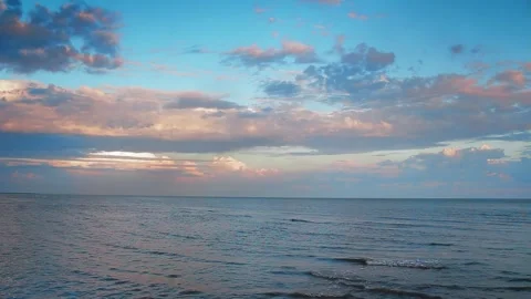 Sunset beach with tranquil ocean waves, pink-blue sky. Gentle sea ripples Stock Footage 260719274