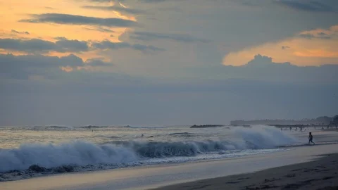 Sunset beach in twilight with high tide waves and people in ocean are swimming Video stock 113604090