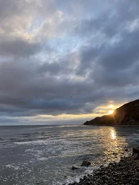 Sunset Beach View of the Pacific Ocean and Storm Clouds Overlooking Natural Reef Stock Photos