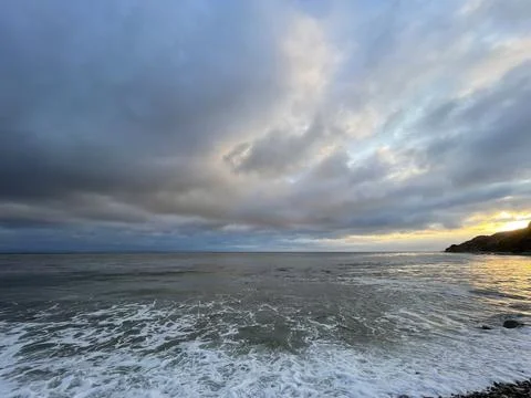 Sunset Beach View of the Pacific Ocean and Storm Clouds Overlooking Natural Reef Stock Photos
