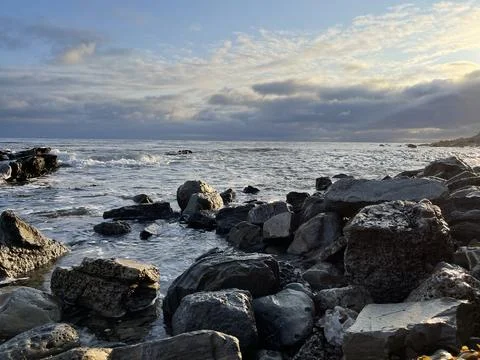 Sunset Beach View of the Pacific Ocean and Storm Clouds Overlooking Natural Reef Stock Photos