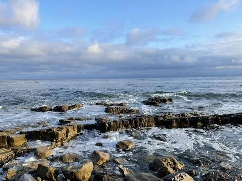 Sunset Beach View of the Pacific Ocean and Storm Clouds Overlooking Natural Reef Stock Photos