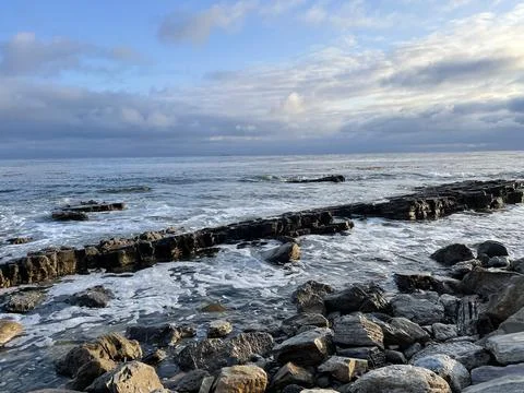 Sunset Beach View of the Pacific Ocean and Storm Clouds Overlooking Natural Reef Stock Photos