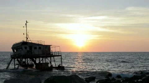 Sunset at beach with watchtower on sunken boat Stock Footage 49684092