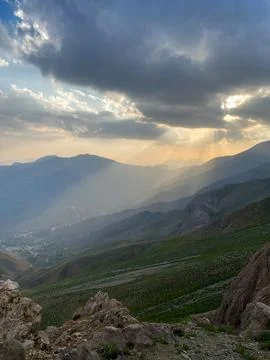 Sunset beam against the background of multi-level mountains and mountain meadows Stock Photos