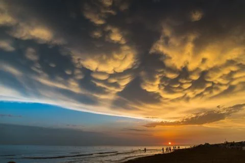 Sunset with beautiful clouds over the seashore Stock Photos