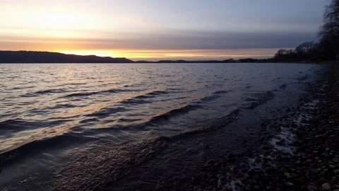 Sunset on beautiful Lake Constance with waves and colorful clouds in the sky Stock Footage 229811389