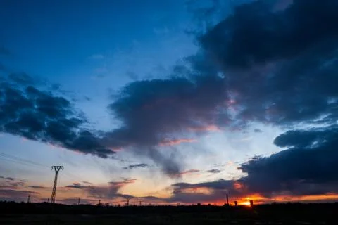 Sunset with a beautiful sky on a golf course and a coal mine in the backgroun Stock Photos