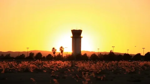 Sunset behind air traffic tower as helicopter flies by Stock Footage 85148596