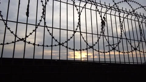 Sunset Behind Barbed Wire Fence, Striking Silhouettes and Fiery Sky Colors Stock Footage 300890899