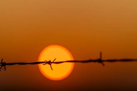 The Sunset Behind Barbed Wire A Powerful and Striking Contrast in Natures Beauty Stock Photos