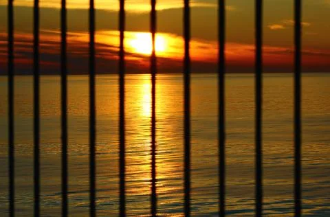 The sunset behind the bars Stock Photos
