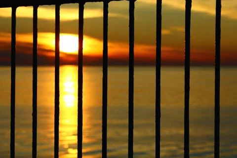 The sunset behind the bars Stock Photos