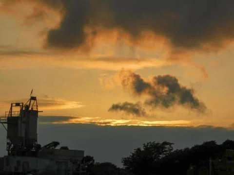 Sunset behind clouds at a construction site Stock Photos