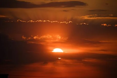 Sunset behind the clouds, orange sky. beautiful sunset Stock Photos