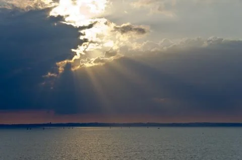 Sunset behind clouds over the sea Stock Photos