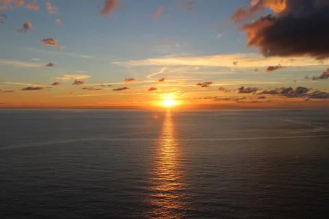 Sunset behind clouds over the sea Stock Photos