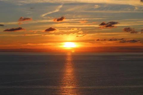 Sunset behind clouds over the sea Stock Photos