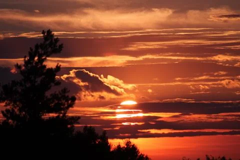 Sunset behind clouds Stock Photos