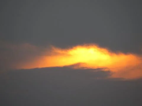 Sunset behind clouds Stock Photos