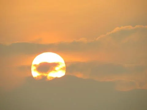 Sunset behind clouds Stock Photos