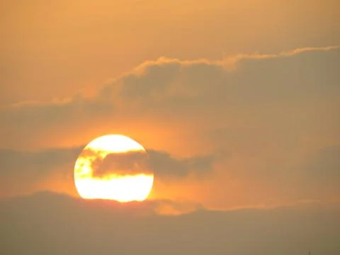 Sunset behind clouds Stock Photos