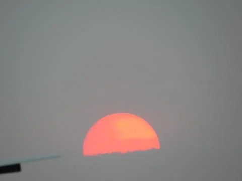 Sunset behind clouds Stock Photos