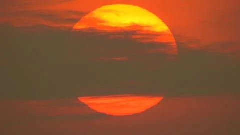 Sunset behind clouds Stock Photos