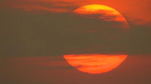 Sunset behind clouds Stock Photos