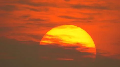 Sunset behind clouds Stock Photos