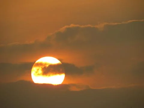 Sunset behind clouds Stock Photos