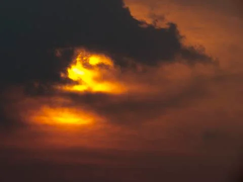 Sunset behind clouds Stock Photos