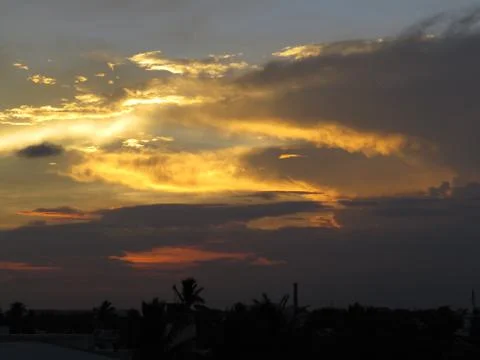 Sunset behind clouds Stock Photos