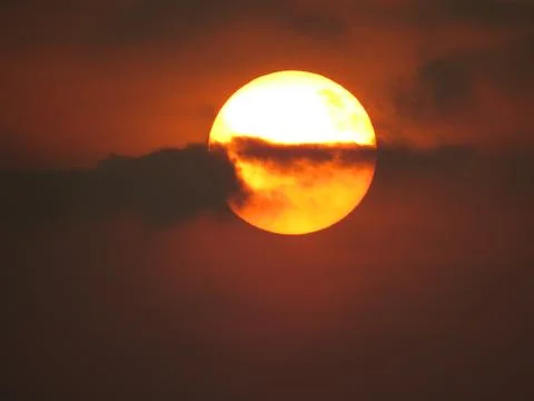 Sunset behind clouds Stock Photos