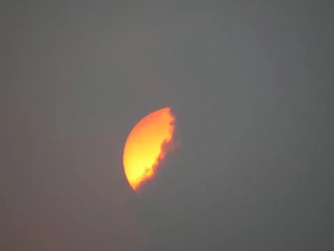 Sunset behind clouds Stock Photos