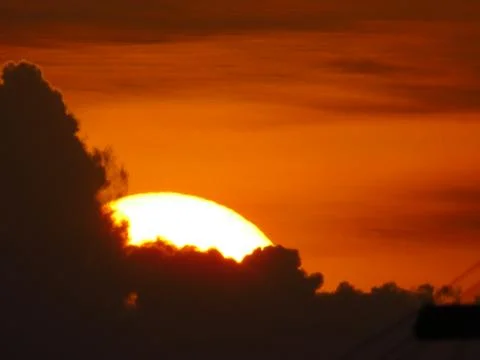 Sunset behind clouds Stock Photos