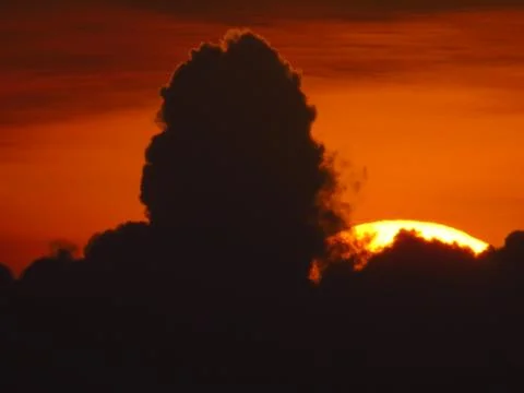 Sunset behind clouds Stock Photos