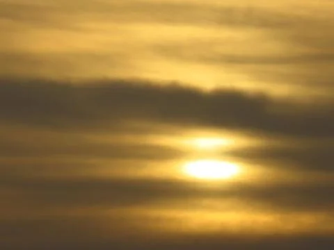 Sunset behind clouds Stock Photos