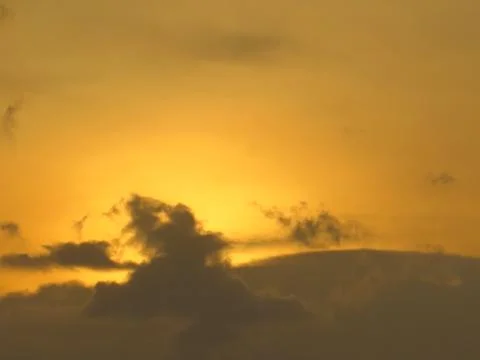 Sunset behind clouds Stock Photos