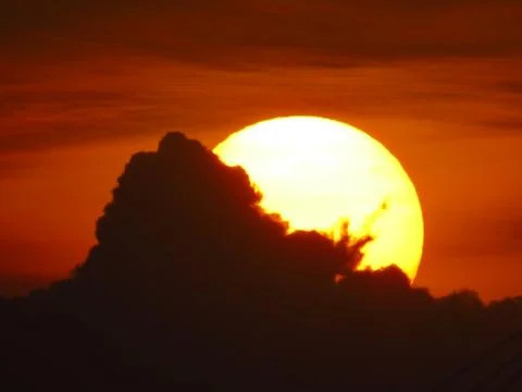 Sunset behind clouds Stock Photos