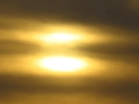 Sunset behind clouds Stock Photos