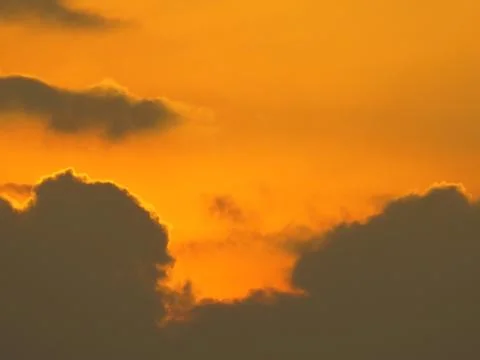 Sunset behind clouds Stock Photos