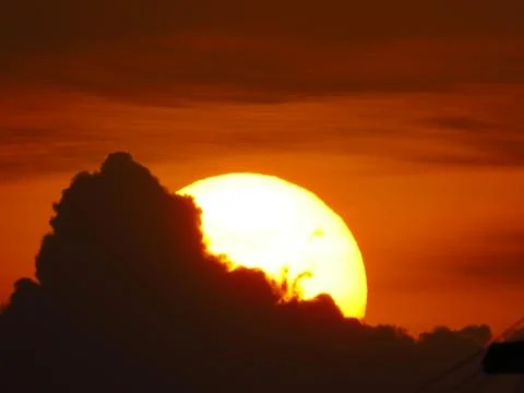 Sunset behind clouds Stock Photos