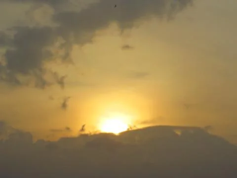 Sunset behind clouds Stock Photos