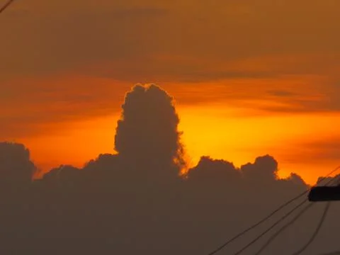 Sunset behind clouds Stock Photos