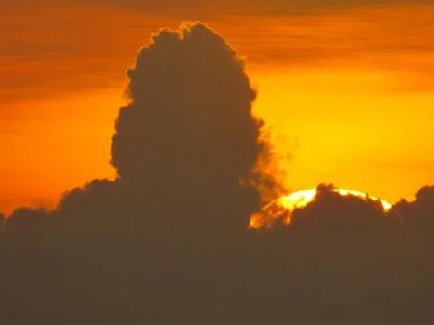 Sunset behind clouds Stock Photos