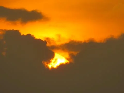 Sunset behind clouds Stock Photos