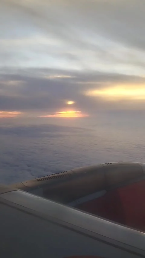 Sunset behind clouds from a Plane Window Over the Ocean Video stock 281835739